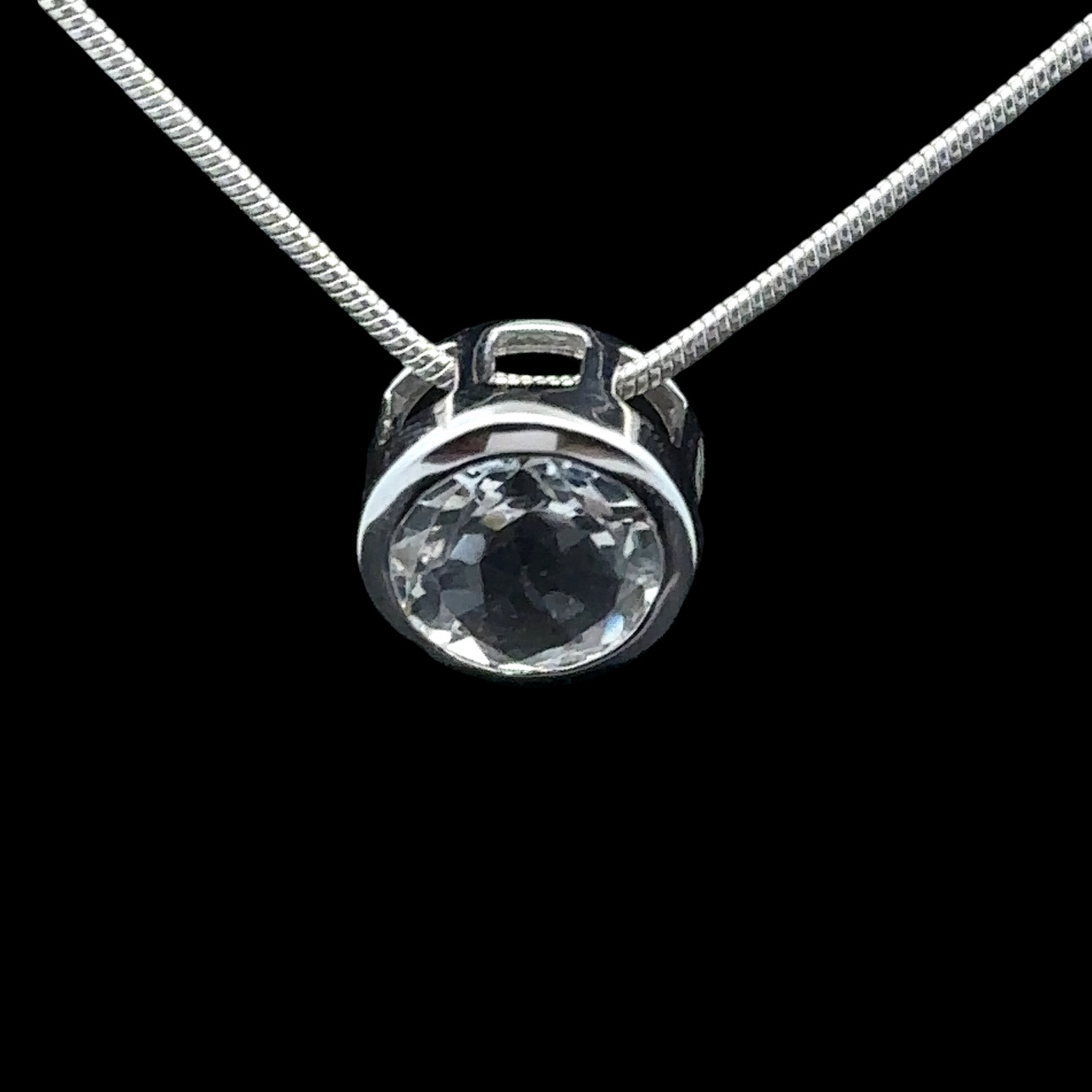 Faceted round rock crystal and rhodium-plated silver pendant