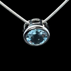 Round faceted blue topaz and rhodium-plated silver pendant